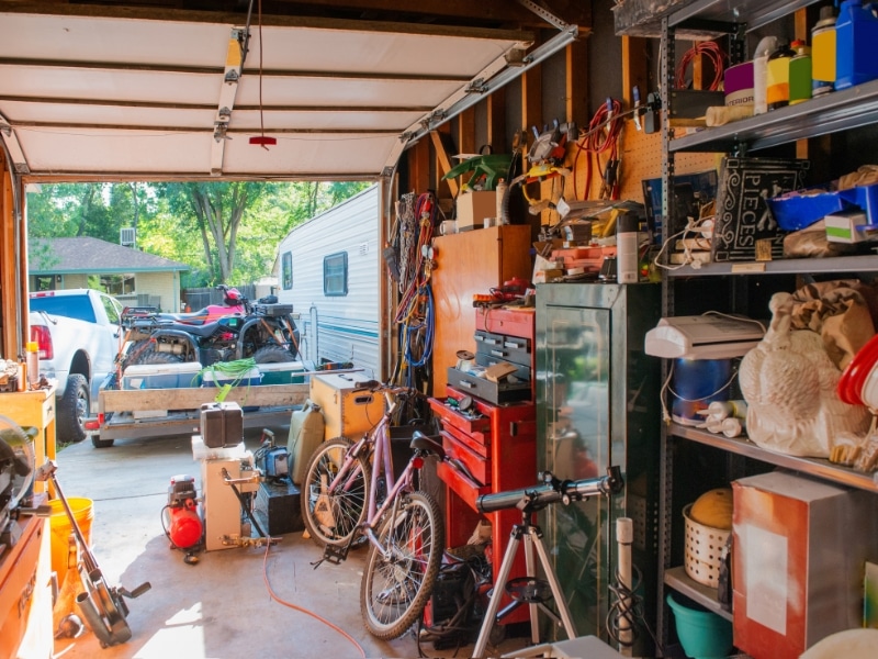 A cluttered garage filled with tools, bikes, and storage — real-life scene of how to declutter a hoarders home.